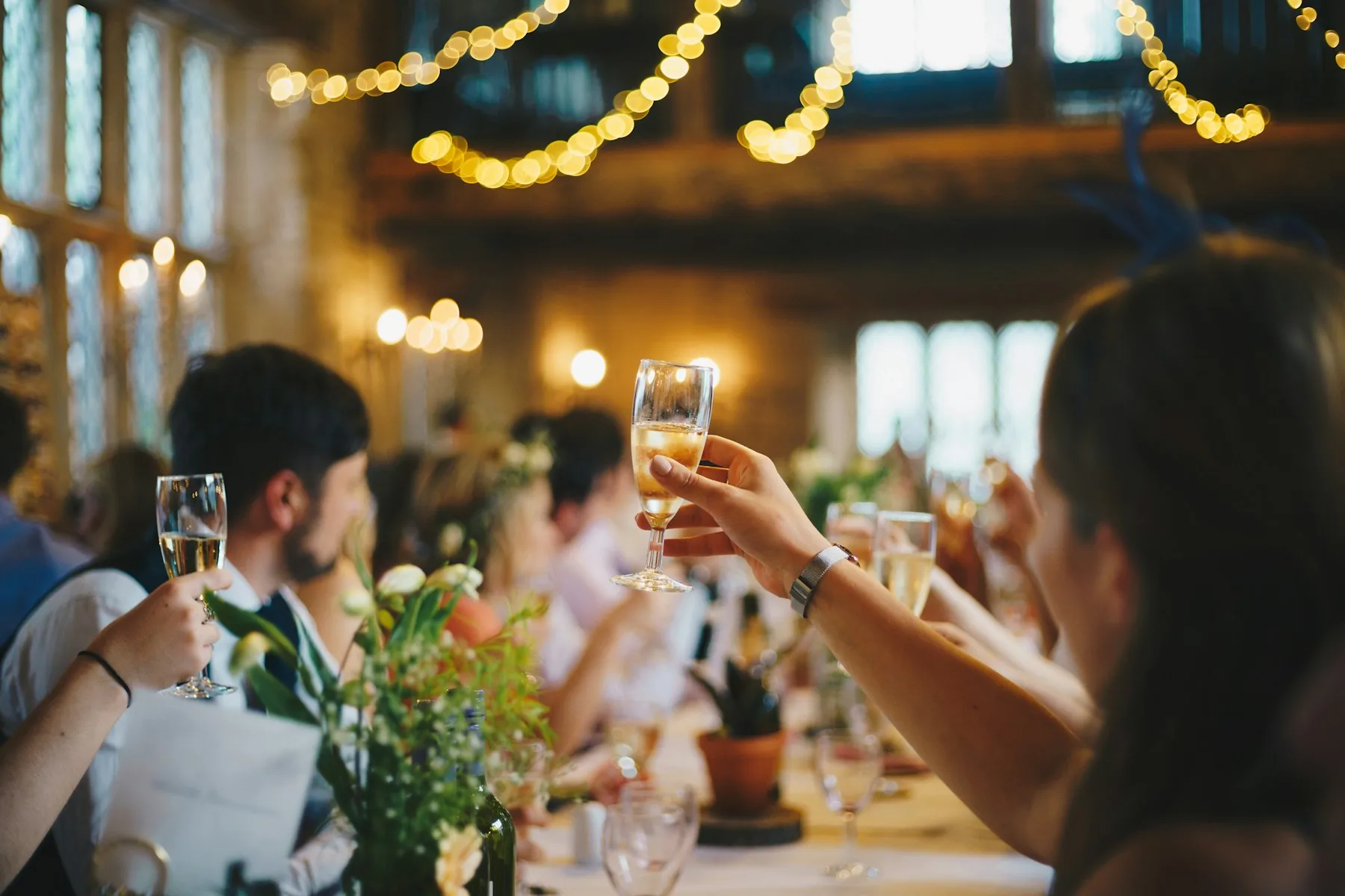 Gäste stossen bei einer Jubiläumsfeier mit Champagner an
