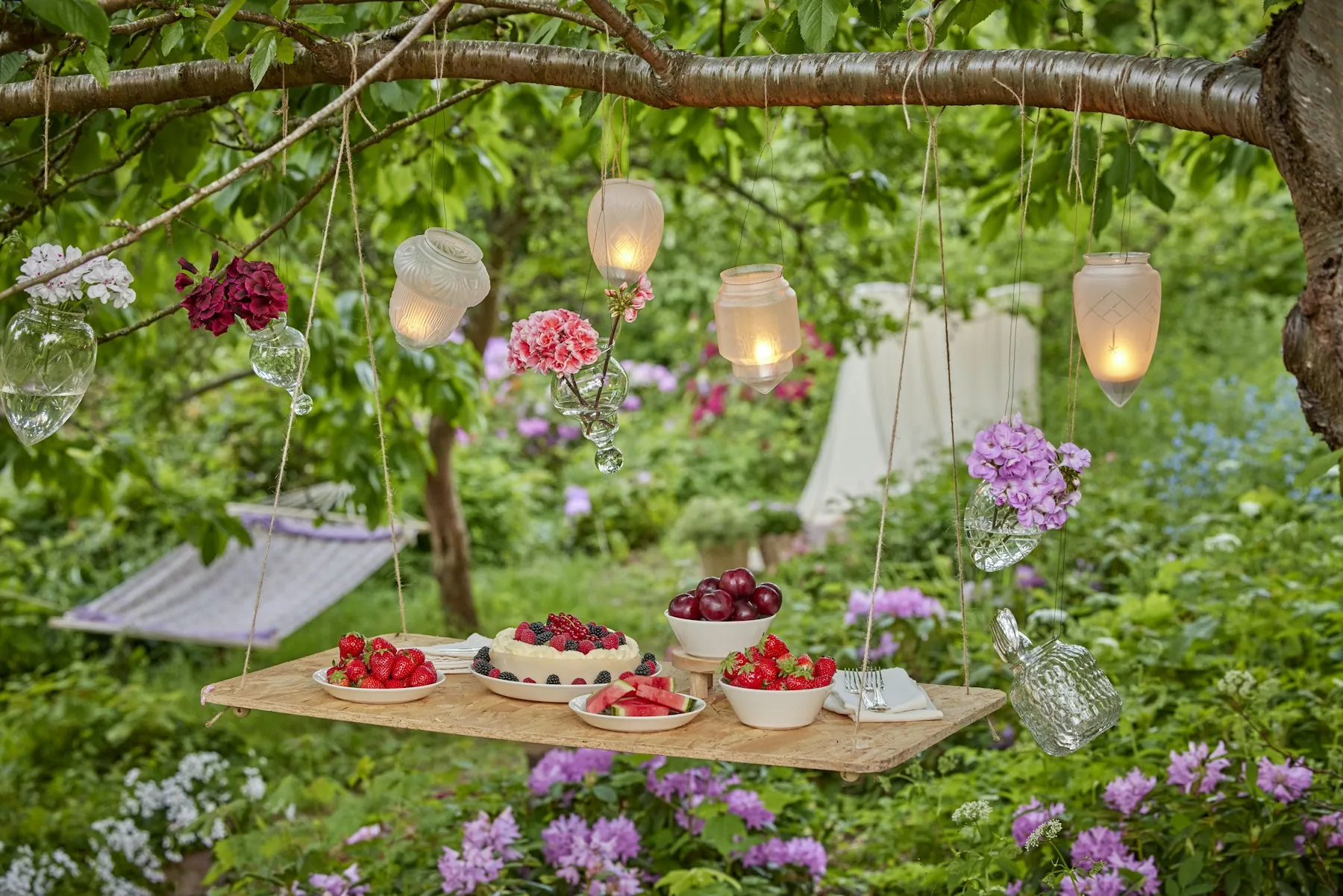 Stilvolle Gartenparty mit Lichtern und floraler Dekoration
